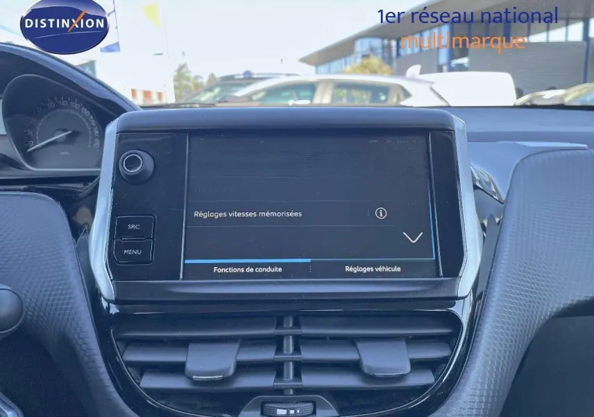 Vue rapprochée de la console centrale tactile du Peugeot 2008 blanc, affichant les réglages de vitesses mémorisées.