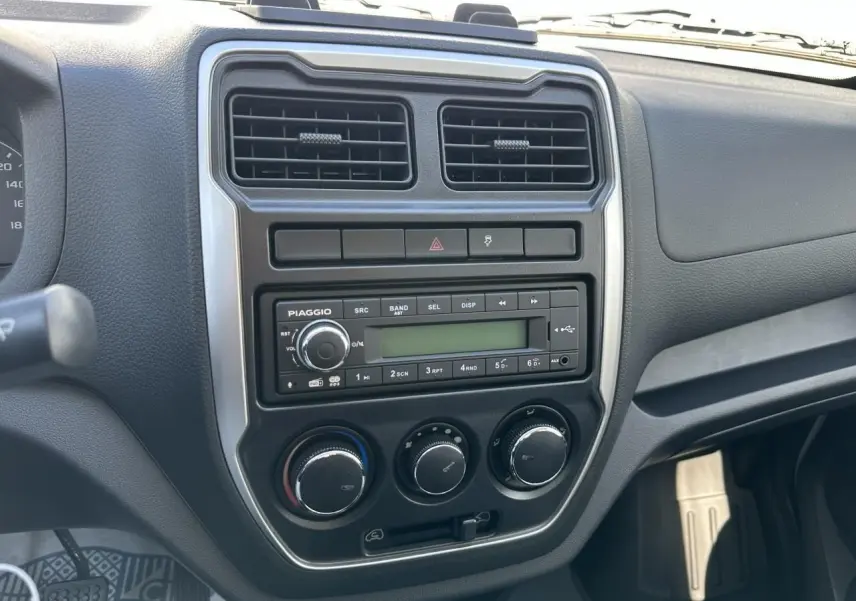 Tableau de bord du Piaggio Porter 2024, vue de face sur la console centrale avec radio et commandes climatiques.
