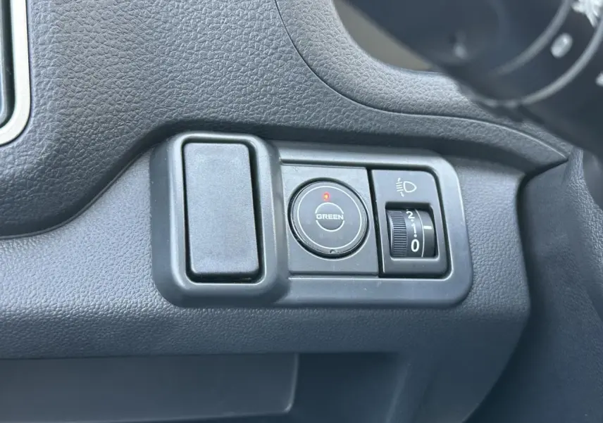 Détail du tableau de bord du Piaggio Porter 2024 montrant les commandes d'éclairage et mode Green en plastique noir.