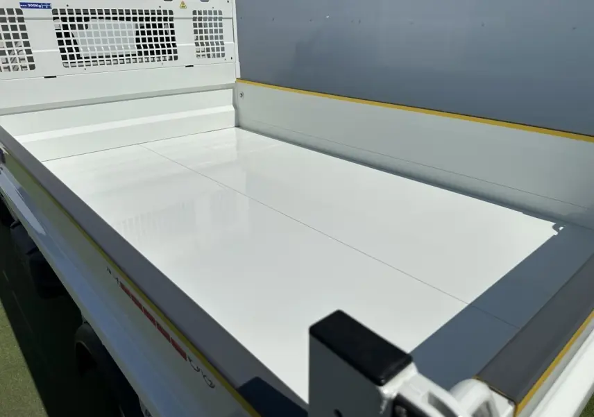 Vue en plongée sur la benne blanche du Piaggio Porter NP6 SWB, soulignant sa surface lisse et ses protections latérales.