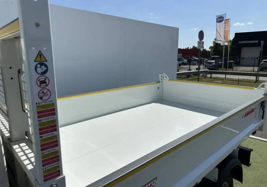 Benne blanche vue en 3/4 arrière droit du Piaggio Porter 2024 avec plateau de chargement long et bordures jaunes.