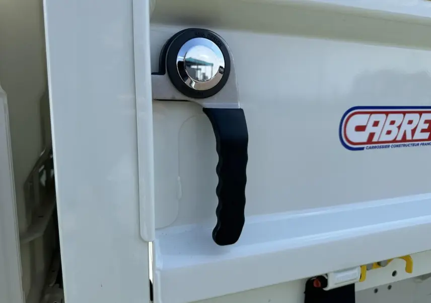Poignée de benne blanche du Piaggio Porter 2024 vue de près, avec logo Cabreta visible sur la tôle.