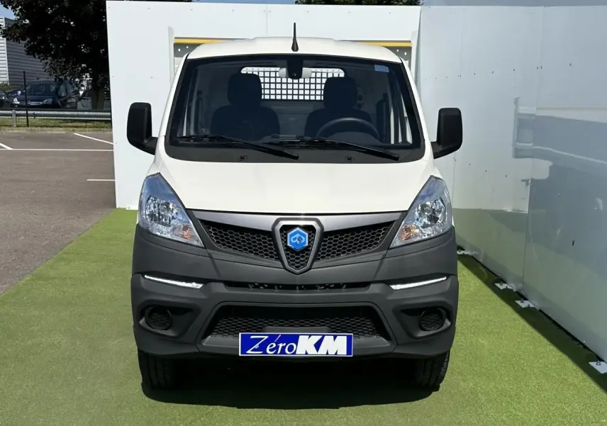 Vue de face du utilitaire blanc Piaggio Porter NP6 avec calandre noire et plaque d'immatriculation Zéro KM visible.