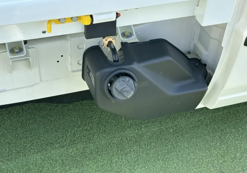 Gros plan sur le réservoir GPL noir sous la benne blanche du Piaggio Porter NP6 SWB côté gauche.