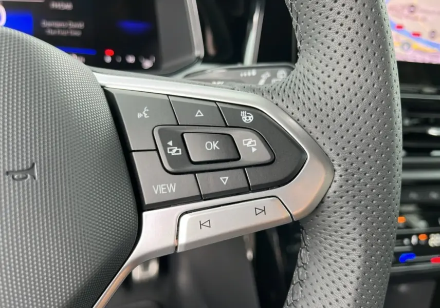 Gros plan sur les commandes à droite du volant perforé du Volkswagen T-Roc gris indium 2025 R-Line Black.
