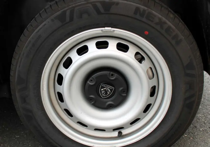 Gros plan sur la roue acier blanche du Peugeot Partner Fourgon 2025 avec logo lion au centre du moyeu.