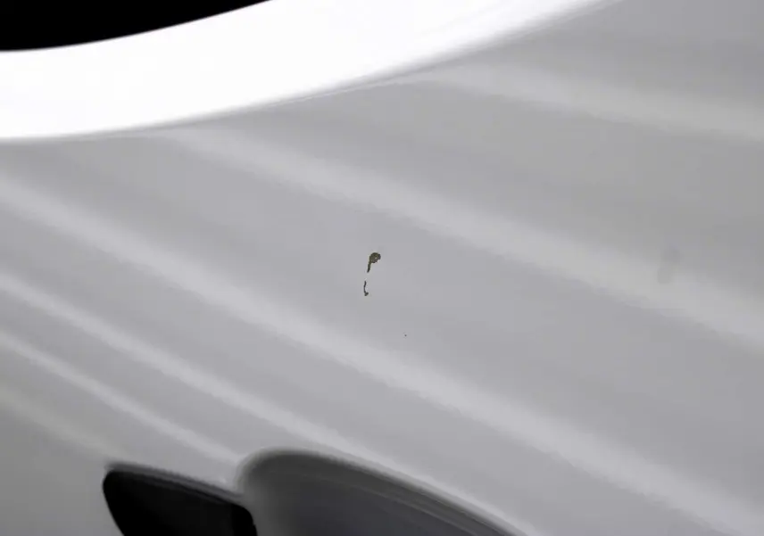 Gros plan sur la porte blanche du Peugeot Partner Fourgon 2025, mettant en valeur la poignée noire et la carrosserie lisse.