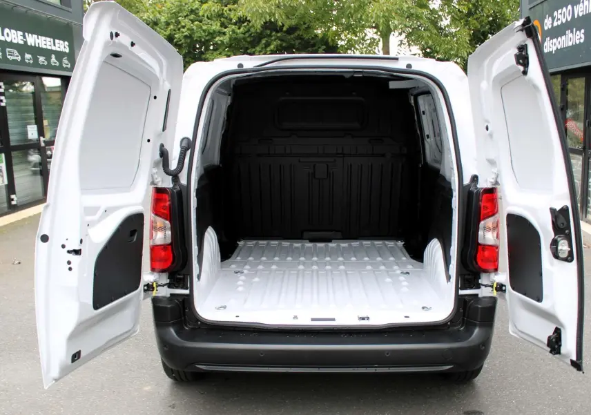 Vue arrière du Peugeot Partner Fourgon blanc 2025 avec portes arrière ouvertes montrant l'espace de chargement vide.