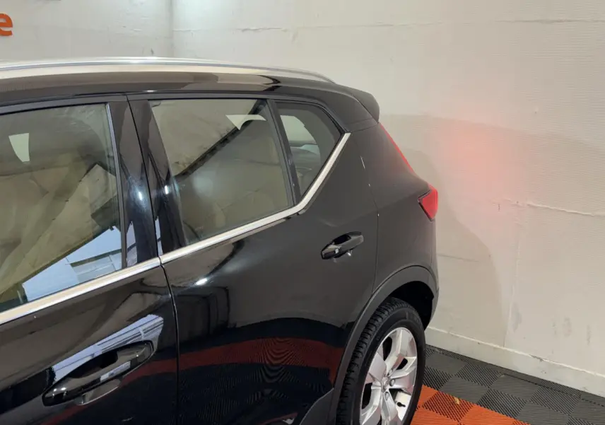 Vue côté droit arrière du Volvo XC40 noir Recharge T5 Inscription avec jante argentée et contour de vitre chromé.