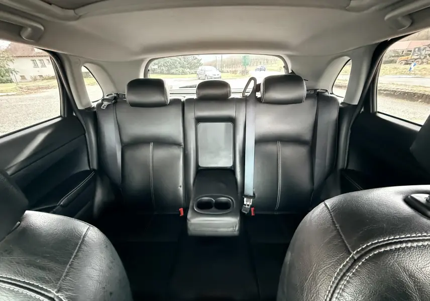 Vue intérieure arrière du Mitsubishi ASX 2015 montrant les sièges en cuir noir avec accoudoir central rabattable.