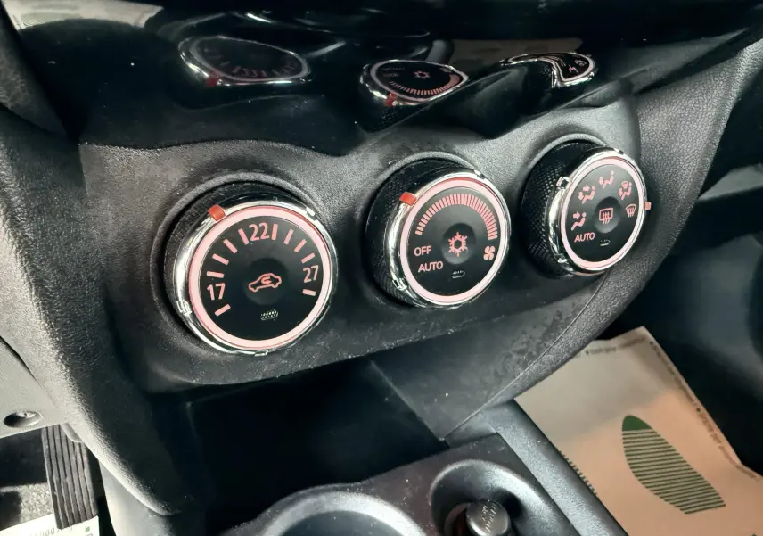 Gros plan sur les commandes de climatisation du Mitsubishi ASX 2015, avec réglages circulaires rétroéclairés en rouge.