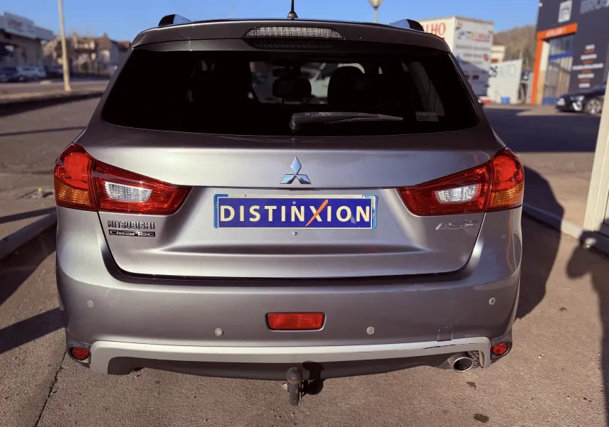 Vue arrière d'un Mitsubishi ASX gris 2015 avec feux rouges et attelage visible au centre.