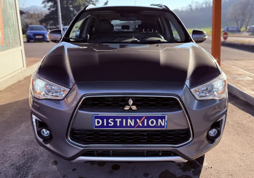 Vue avant d’un Mitsubishi ASX gris 2015 avec calandre noire et plaque Distinxion visible au centre.