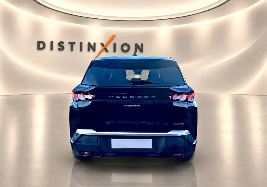 Vue arrière du Peugeot 5008 Hybrid 145 GT noir, avec feux LED distinctifs et logo centré sur un fond lumineux.