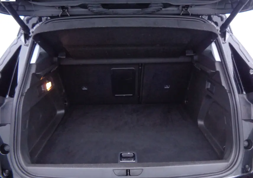 Coffre ouvert de l'Opel Grandland X noir métal, vue arrière montrant l'espace de chargement vide et l'éclairage intérieur.
