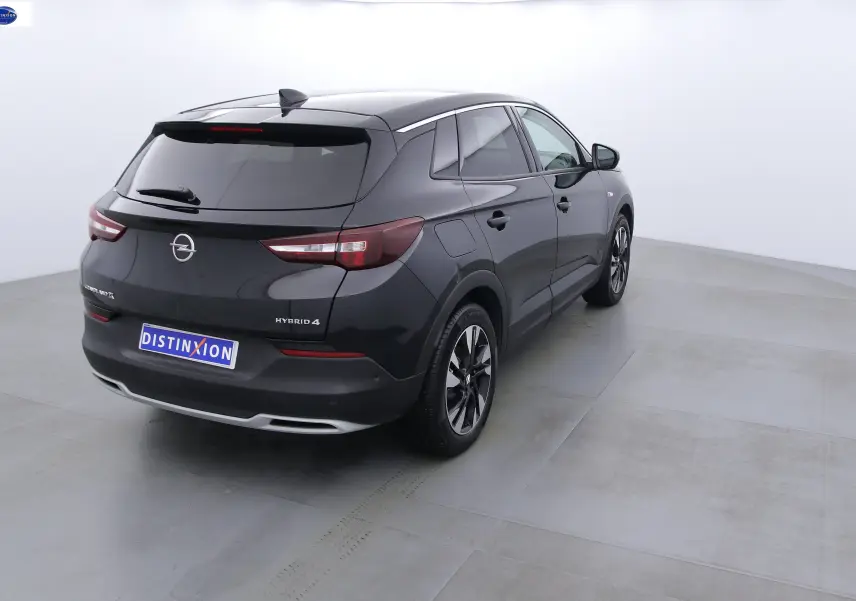 Opel Grandland X hybride rechargeable noir métal vu de 3/4 arrière droit avec jantes noires et grises.