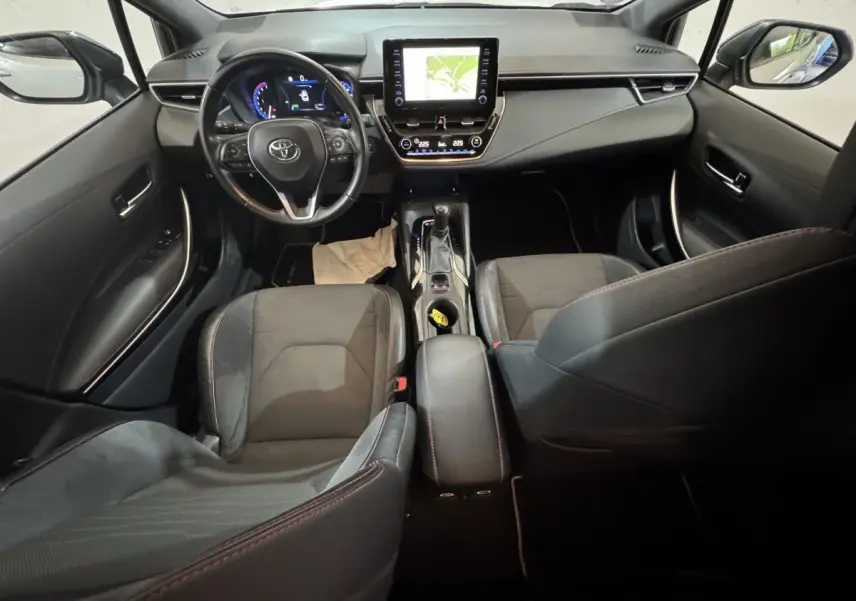 Vue intérieure avant de la Toyota Corolla Hybride 122h Collection 2021, tableau de bord avec écran tactile et volant cuir noir.