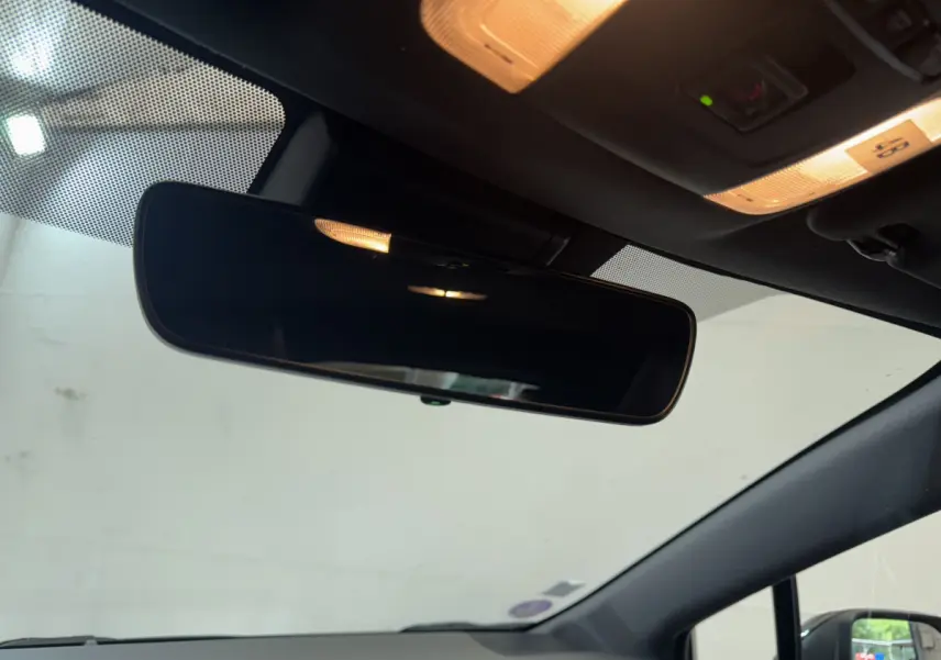 Vue intérieure du rétroviseur central et du plafonnier éclairé de la Toyota Corolla Hybride gris clair de 2021.