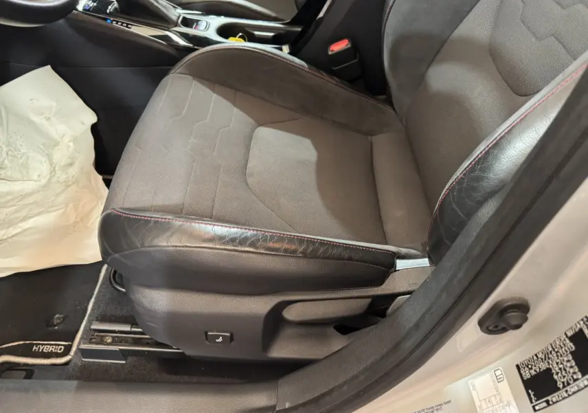 Vue rapprochée du siège conducteur gris et noir avec surpiqûres rouges de la Toyota Corolla Hybride 122h Collection 2021.