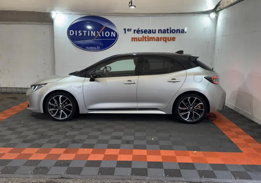Vue latérale droite d'une Toyota Corolla Hybride 122h Collection gris clair avec toit noir et jantes alliage sport.