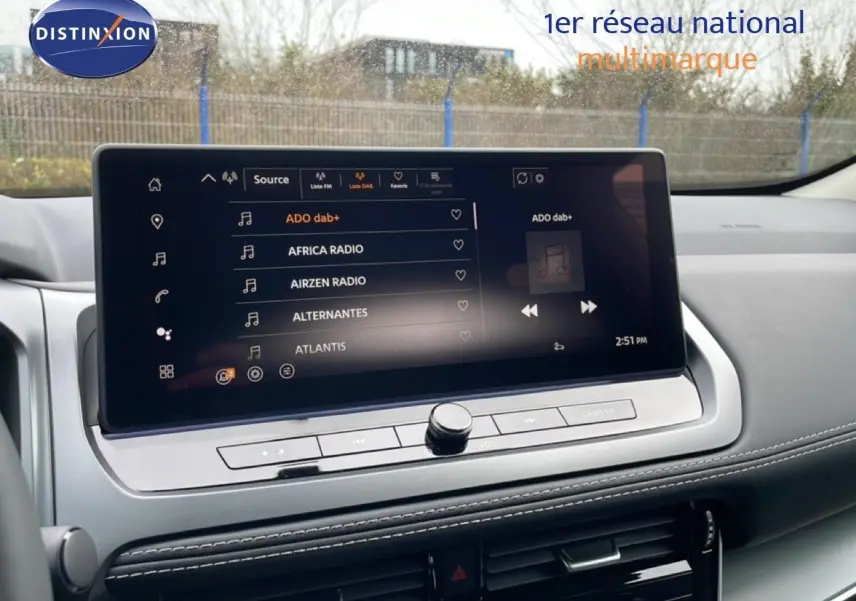 Écran tactile central du Nissan Qashqai 2025 gris squale metal, affichant les stations radio en mode multimédia.