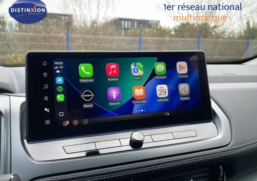 Écran tactile central du Nissan Qashqai 2025 affichant les applications Apple CarPlay, avec tableau de bord gris et finitions modernes.