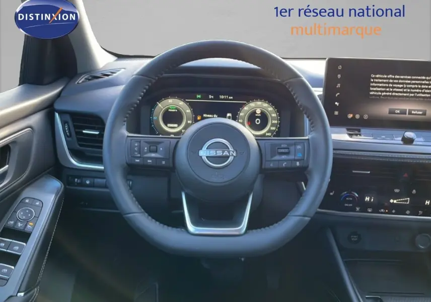 Vue intérieure centrée sur le volant du Nissan Qashqai 2025, tableau de bord numérique et écran tactile visibles.