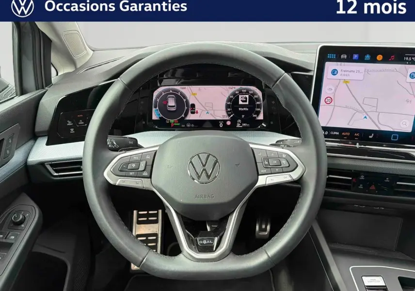 Vue intérieure centrée sur le volant noir de la Volkswagen Golf 1.5 eTSI 2025 avec écran digital et console tactile.
