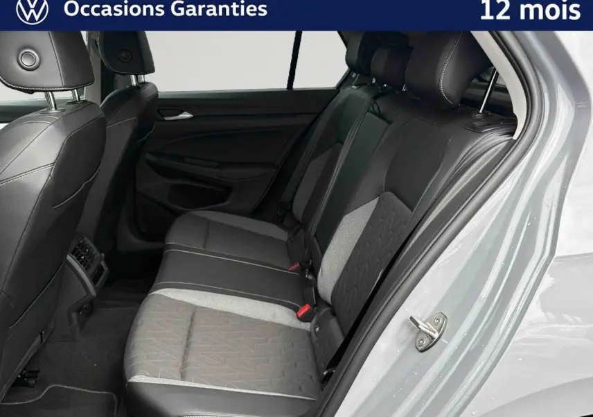 Vue intérieure côté droit sur la banquette arrière grise et noire de la Volkswagen Golf 1.5 eTSI 2025 avec porte ouverte.