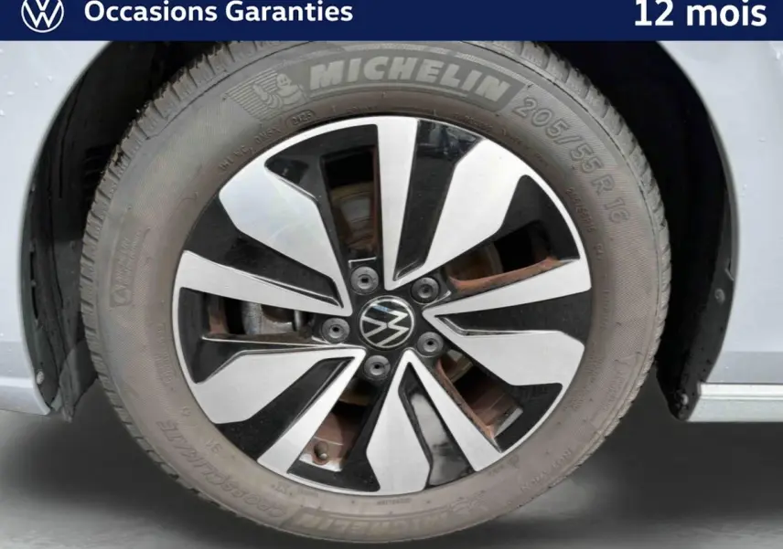 Gros plan sur la jante alliage 16'' Zurich bicolore et pneu Michelin 205/55 R16 d'une Volkswagen Golf grise.