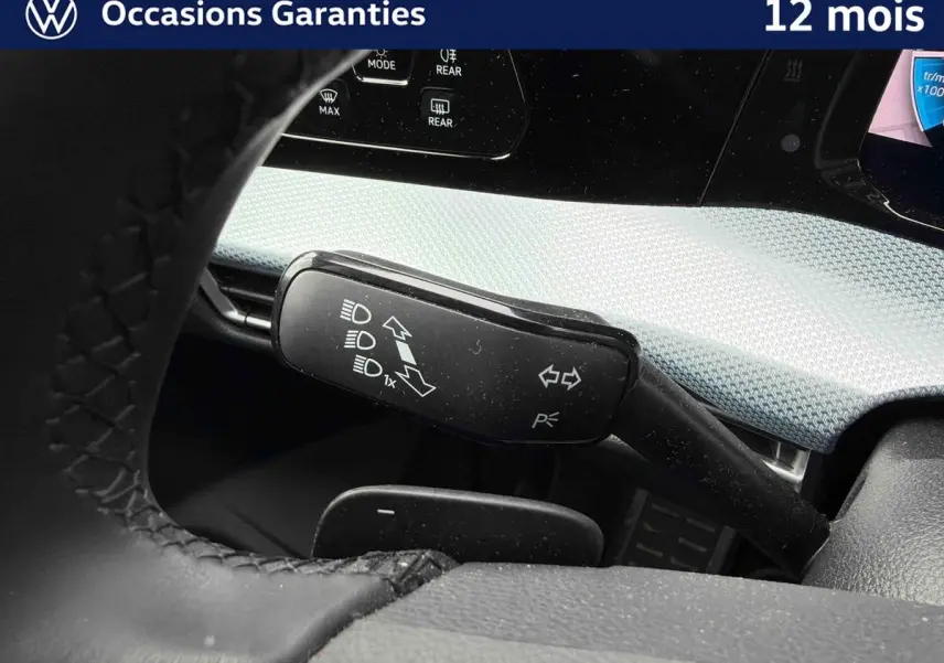 Gros plan sur la commande de clignotants et feux dans l’habitacle gris d’une Volkswagen Golf 1.5 eTSI 2025.
