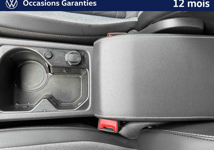 Vue rapprochée de la console centrale grise avec accoudoir et porte-gobelets du Volkswagen Golf 1.5 eTSI 2025.