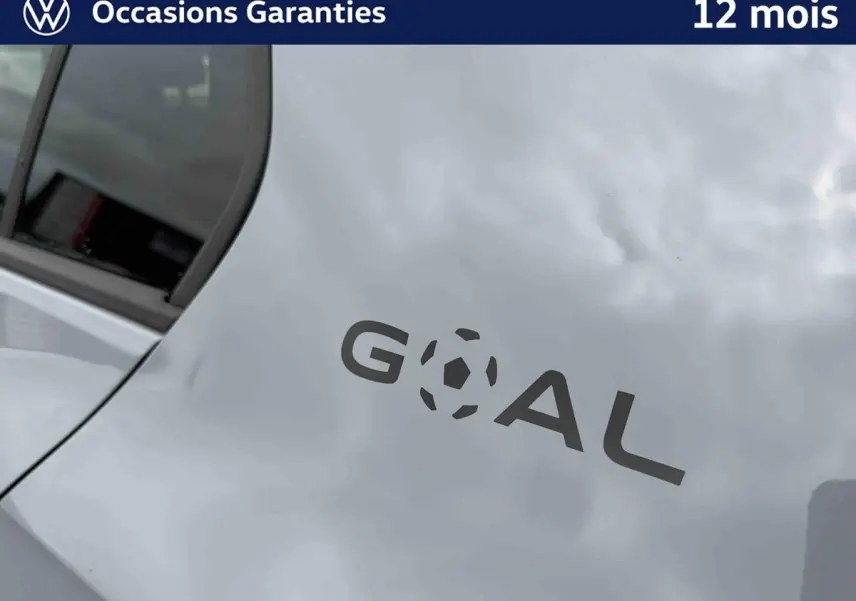 Gros plan sur l'arrière gris d'une Volkswagen Golf avec logo "GOAL" stylisé en noir sur la carrosserie.