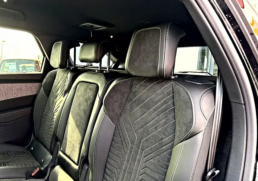 Vue intérieure côté droit sur les sièges arrière noirs en cuir et alcantara du Peugeot 5008 Hybrid 145 GT 2025.