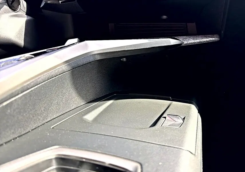 Gros plan sur la boîte à gants fermée côté passager du Peugeot 5008 noir, intérieur moderne et épuré.
