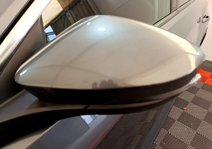 Gros plan sur le rétroviseur droit gris clair du Volkswagen T-Roc 1.0 TSI 110 Lounge Business, avec clignotant intégré.