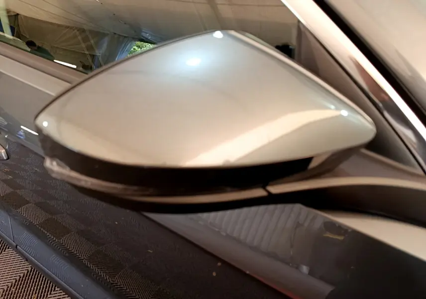 Gros plan sur le rétroviseur droit gris clair du Volkswagen T-Roc 2021, avec clignotant intégré.