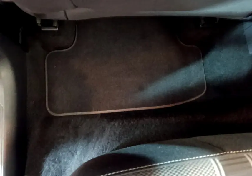 Vue rapprochée du tapis de sol noir côté passager avant du Volkswagen T-Roc gris foncé 2021.