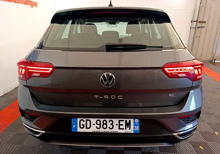 Vue arrière du Volkswagen T-Roc gris foncé 2021 avec feux LED allumés et plaque d'immatriculation française visible.