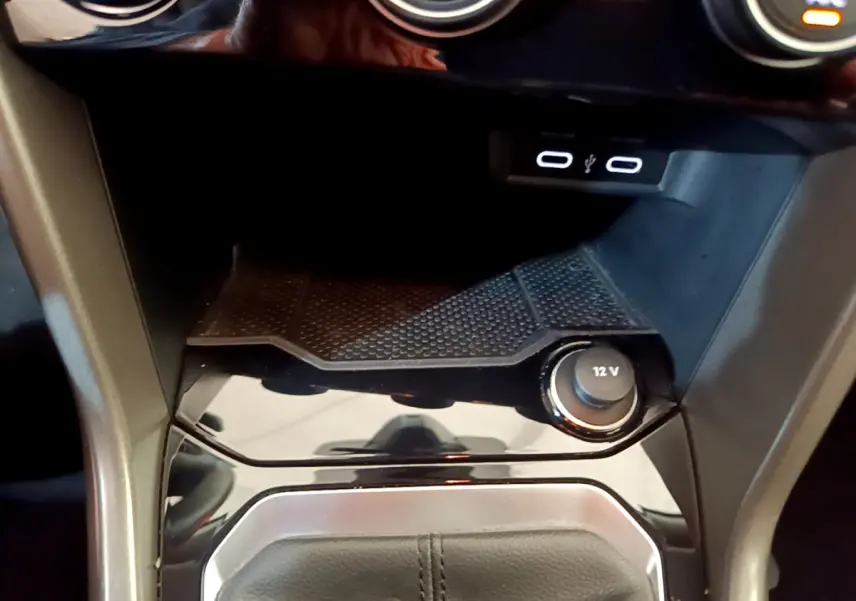Gros plan sur la console centrale du Volkswagen T-Roc 2021, avec prise 12V et ports USB éclairés.