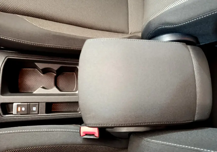 Gros plan sur l'accoudoir central gris foncé et les porte-gobelets du Volkswagen T-Roc 1.0 TSI 110 Lounge Business.