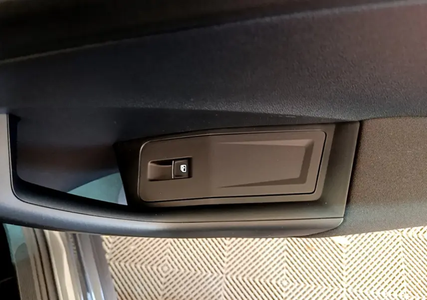 Détail de la poignée intérieure de porte côté conducteur du Volkswagen T-Roc gris foncé, vue rapprochée.
