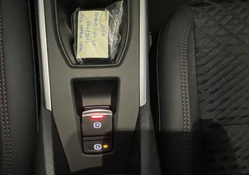 Gros plan sur les commandes au volant à gauche de la Renault Clio VI TCe 115ch Techno, finition noire brillante.