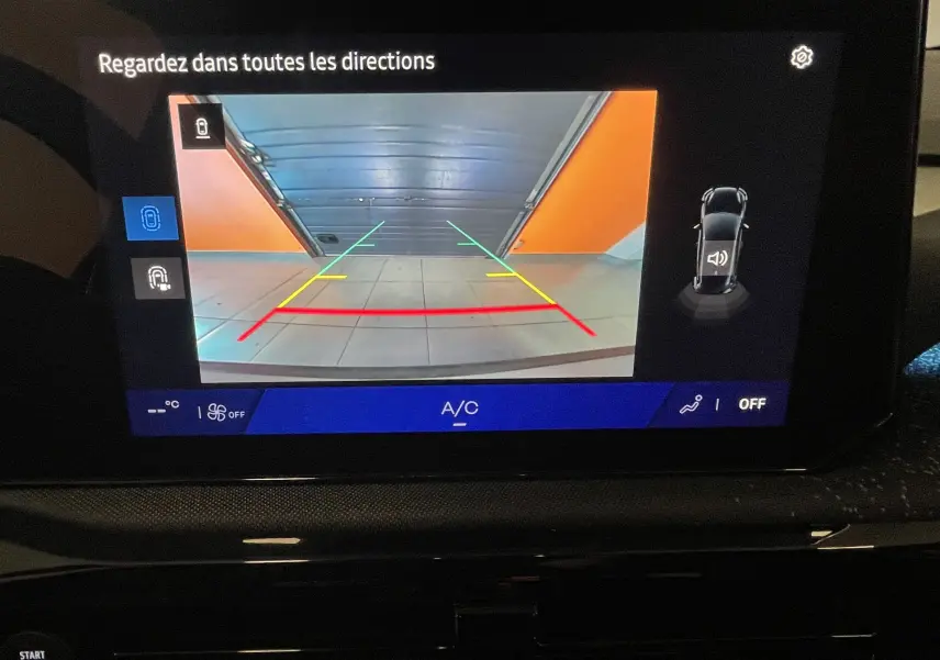 Profil droit de la Renault Clio VI TCe 115ch Techno gris Rafale métal, avec jantes noires et toit noir en showroom.