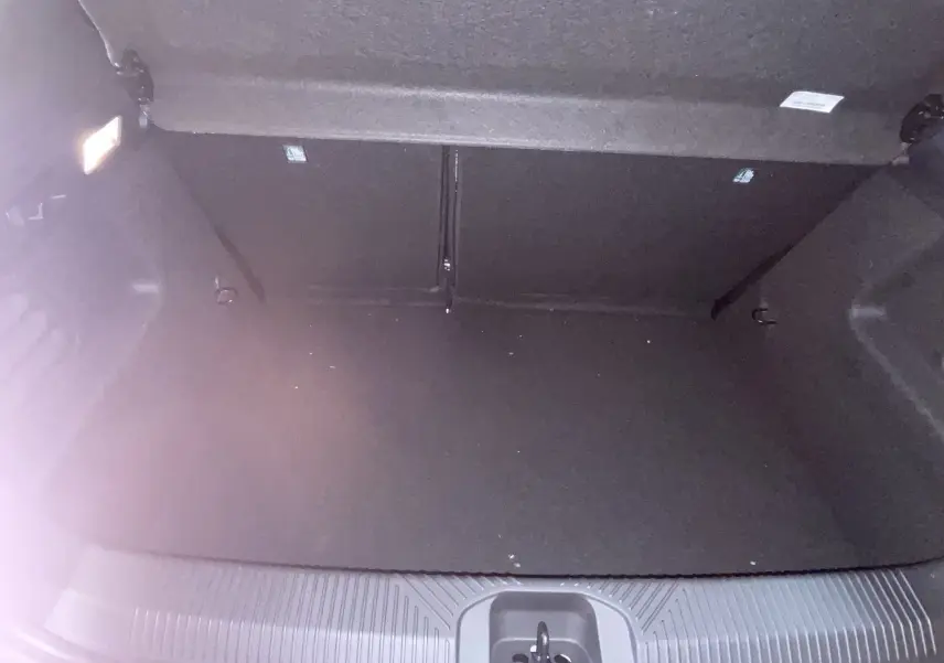 Coffre ouvert de Renault Clio VI TCe 115ch Techno 2026, vue plongeante sur espace gris Rafale métal sans roue de secours.