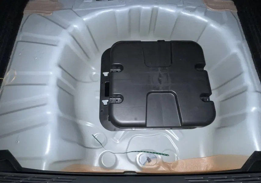 Coffre ouvert de la Renault Clio VI TCe 115ch Techno 2026, vue intérieure, revêtement noir et éclairage latéral.