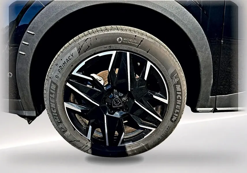 Gros plan sur la roue avant droite noire avec jante alu bicolore du Peugeot 5008 Hybrid 145 GT e-dcs6 noir.