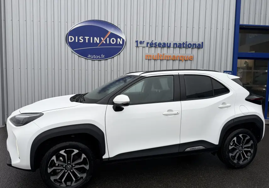 Toyota Yaris Cross blanc pur vue de profil côté gauche, soulignant ses jantes noires et détails noirs contrastants.