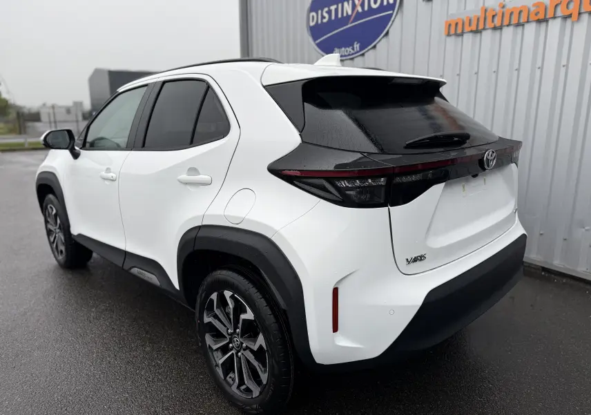 Toyota Yaris Cross blanc pur vue 3/4 arrière droit, avec toit noir et jantes alliage distinctives.