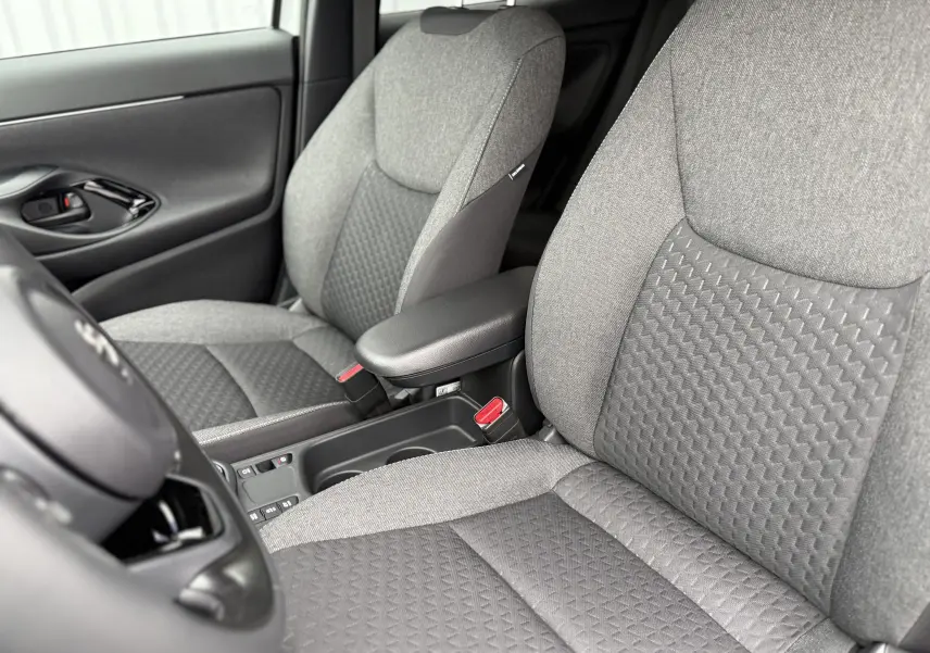 Vue rapprochée des sièges avant gris texturés de la Toyota Yaris Cross 130 CH DESIGN MY25, intérieur moderne et soigné.